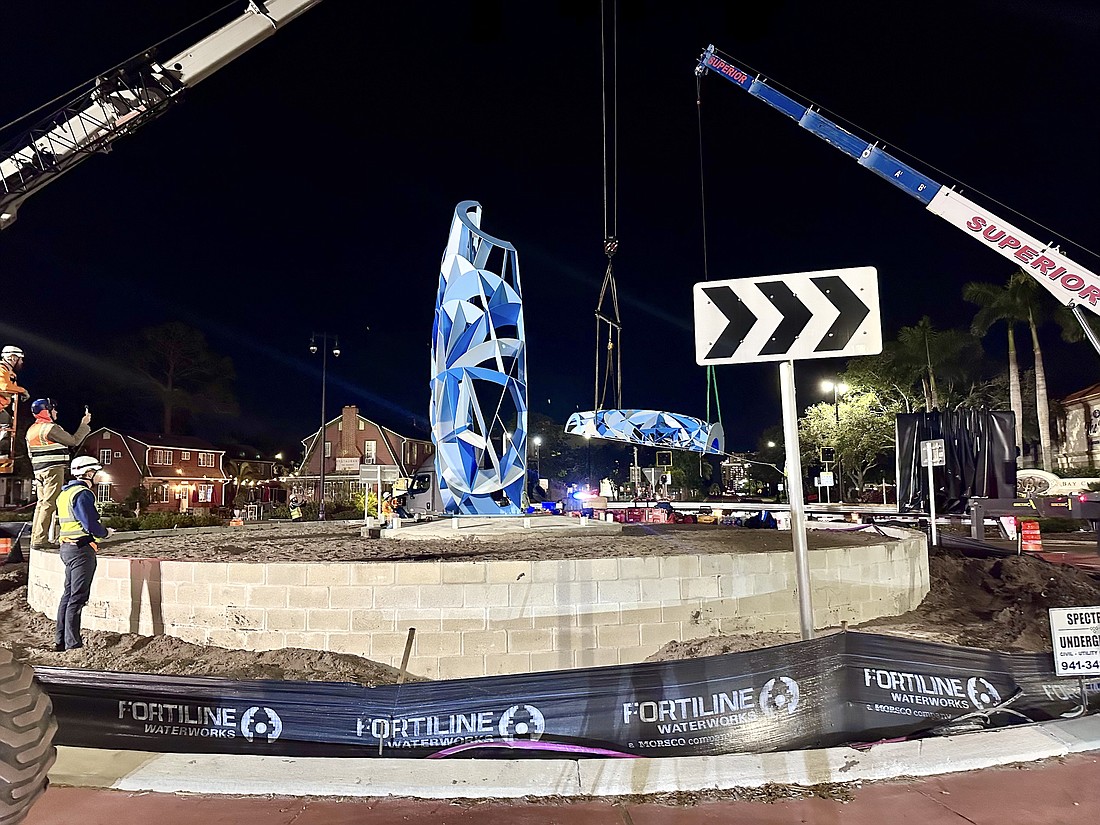 Workers install Poly in the roundabout at U.S. 41 and 14th Street on Wednesday night.