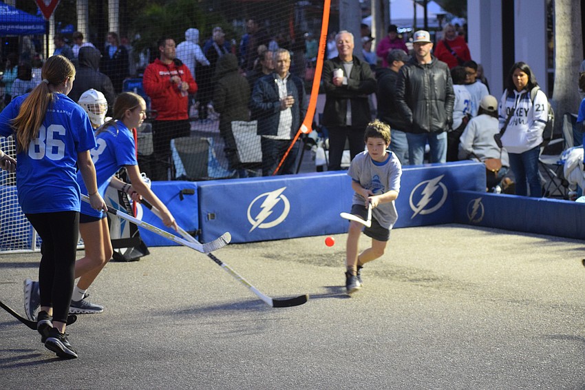 Cal Scott directs the ball away from his team's goal during a round-robin ball hockey tournament held at Lakewood Ranch Main Street on the evening of Saturday, Jan. 11.