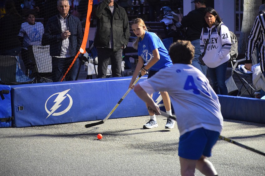 Presley MacDonald looks to pass to a teammate in a ball hockey game before a Tampa Bay Lightning watch party at Lakewood Ranch Main Street on Saturday, Jan. 11.