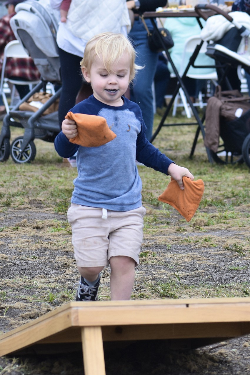 Cooper Register, 2, a visitor from Port Charlotte, takes the cornhole beanbags straight to the goal.