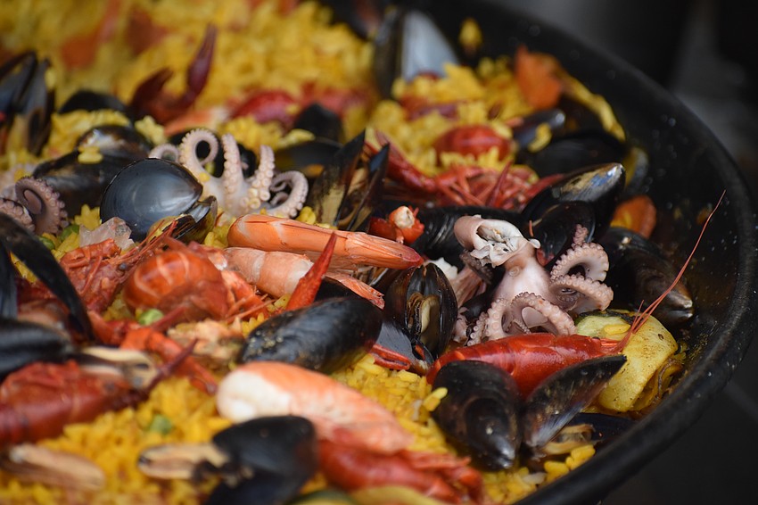 A mixture of seafood sits over a bed of rice.