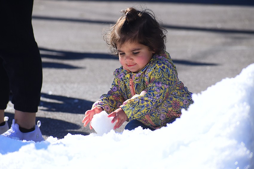 Zuri Mills, 2, plays with a snowball.