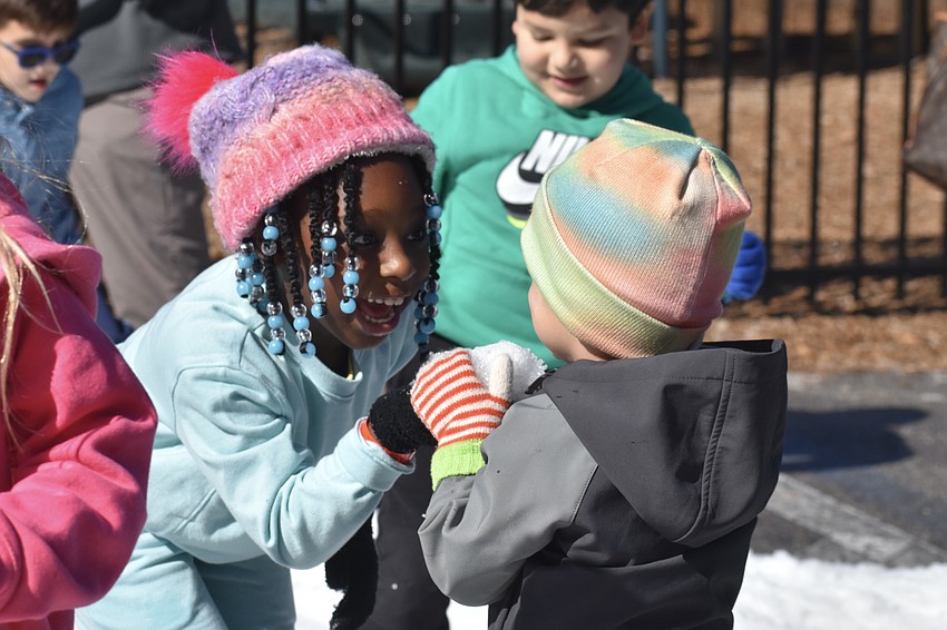 Rylie Charles, 5, gifts a snowball to Colton Woods, 3.