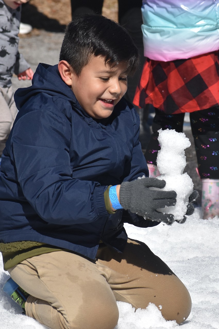 Matthew Tafolla, 6, completes a miniature snowman.