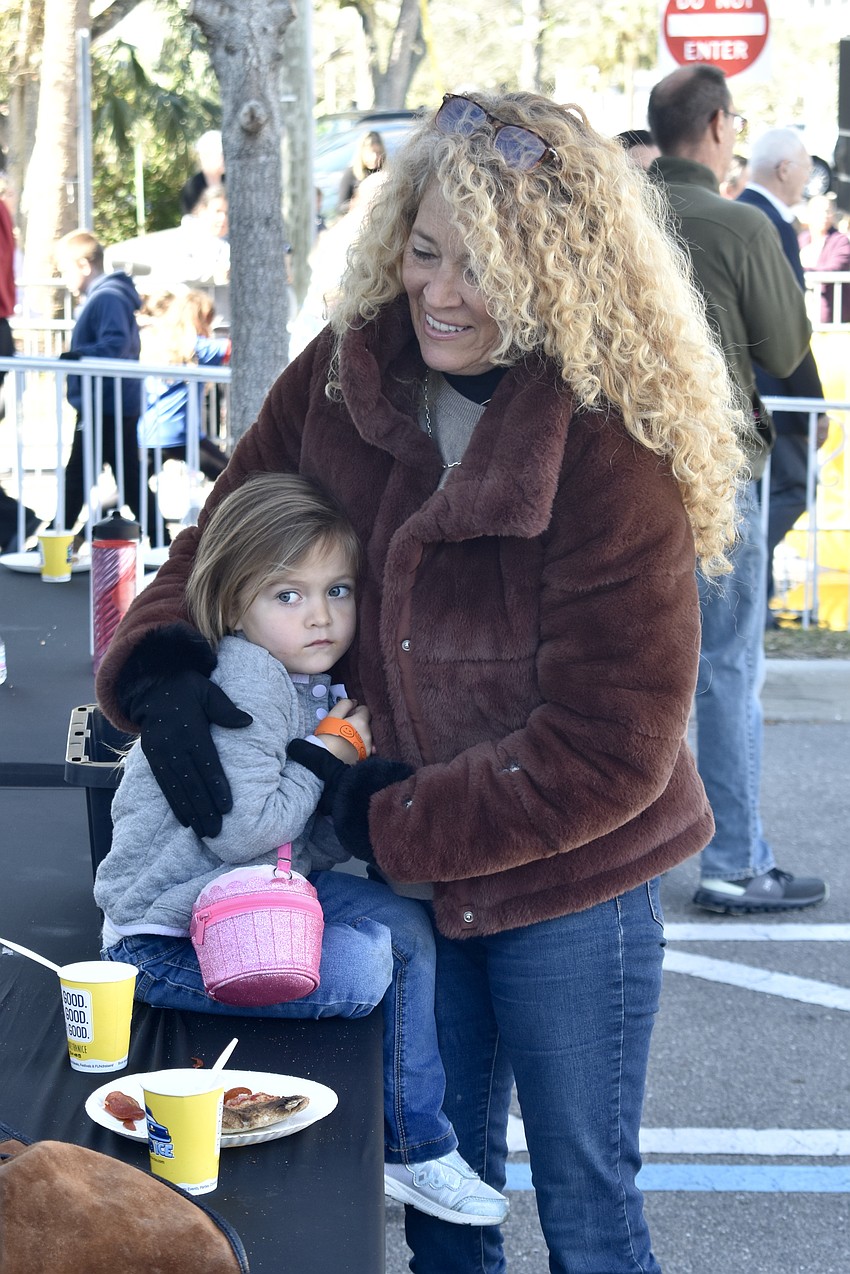 Abbey Moy, 3, who is feeling cold after spending time in the snow, warms up with her grandmother Debi Windham.
