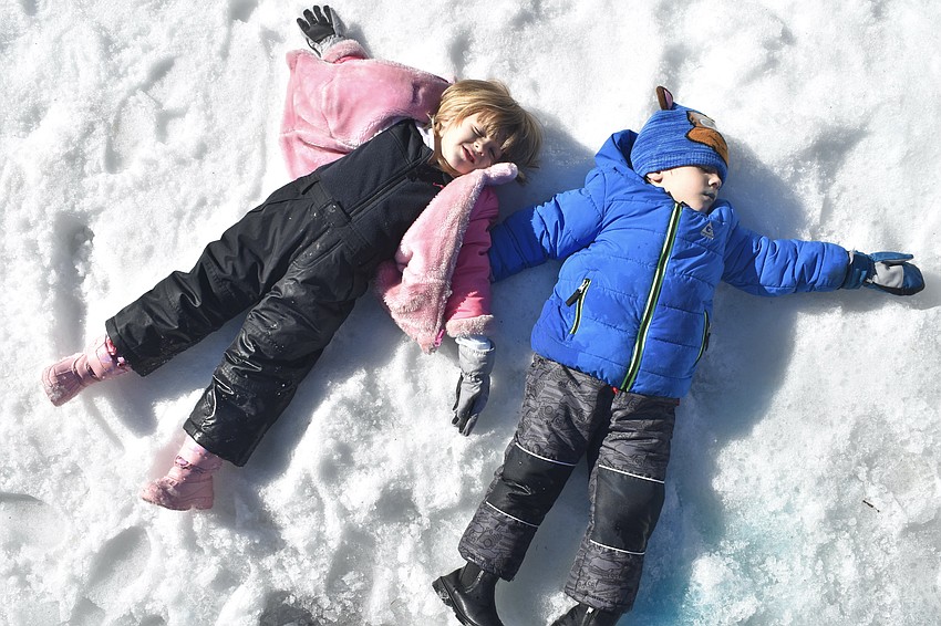 Arleana Croce, 3, and her twin brother Olin Croce, make snow angels.