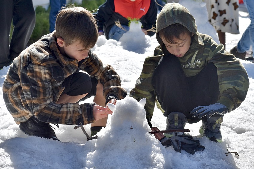 Weston Schurr, 8, and his brother Parker Schurr, 6, build a snowman.