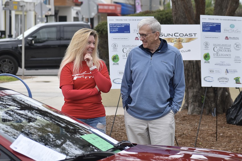 Stacie Johnson showcases her car to attendee Scott Veazey.