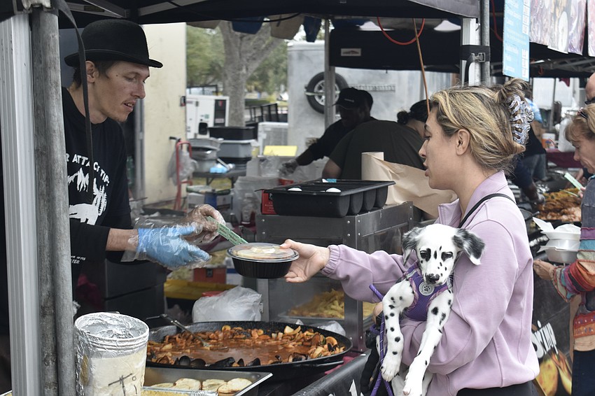 Carlos Dravo hands a dish to Jadyn Rodocker and her dog Otis