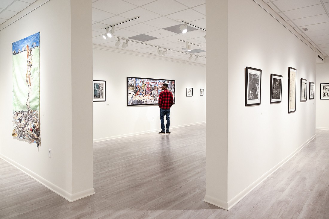 New Yorker Joseph Gyapong examines the piece by artist Charles Humes Jr. whose exhibition is being displayed at the Ormond Memorial Art Museum. Photo by Michele Meyers