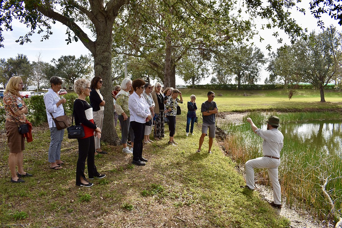 Marine biologist Sean Patton shows the Gardeners Out East a piece of Hydrilla verticillata he plucked out of the pond next to Robert Toale & Sons Celebration of Life Center.