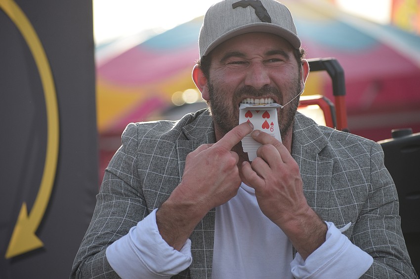 Magic Man TJ Hill does a card trick by finding the card a spectator chose with his mouth during a magic show at the Manatee County Fair on Saturday afternoon.