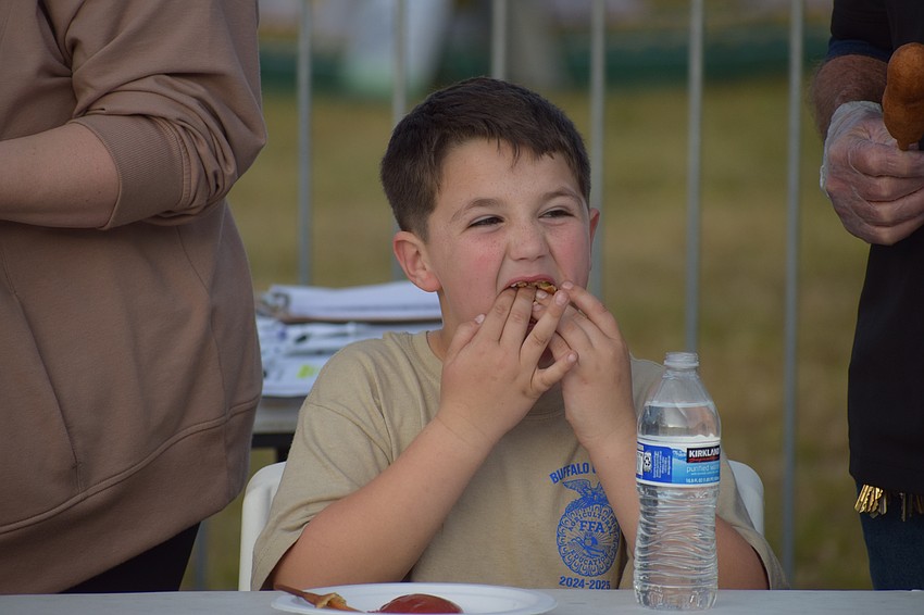 John Myers, 7, tries to maximize his corndog-eating efficiency during the 10th annual corn dog eating contest at the Manatee County Fair.