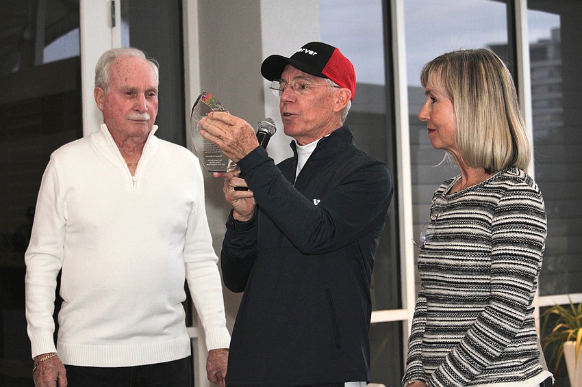 Matt Walsh reads the award given to Kay Thayer for her 25 years coordinating the annual Observer Challenge tennis tournament before giving it to her with Rich McGrath.