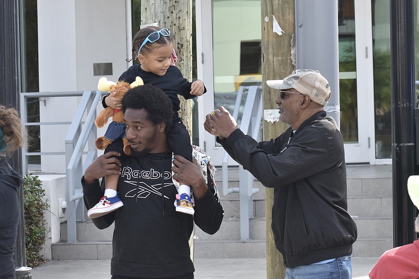 Myles Davenport, his son Makai Davenport, 3, and grandfather Greg Davenport watch the walk come to an end.