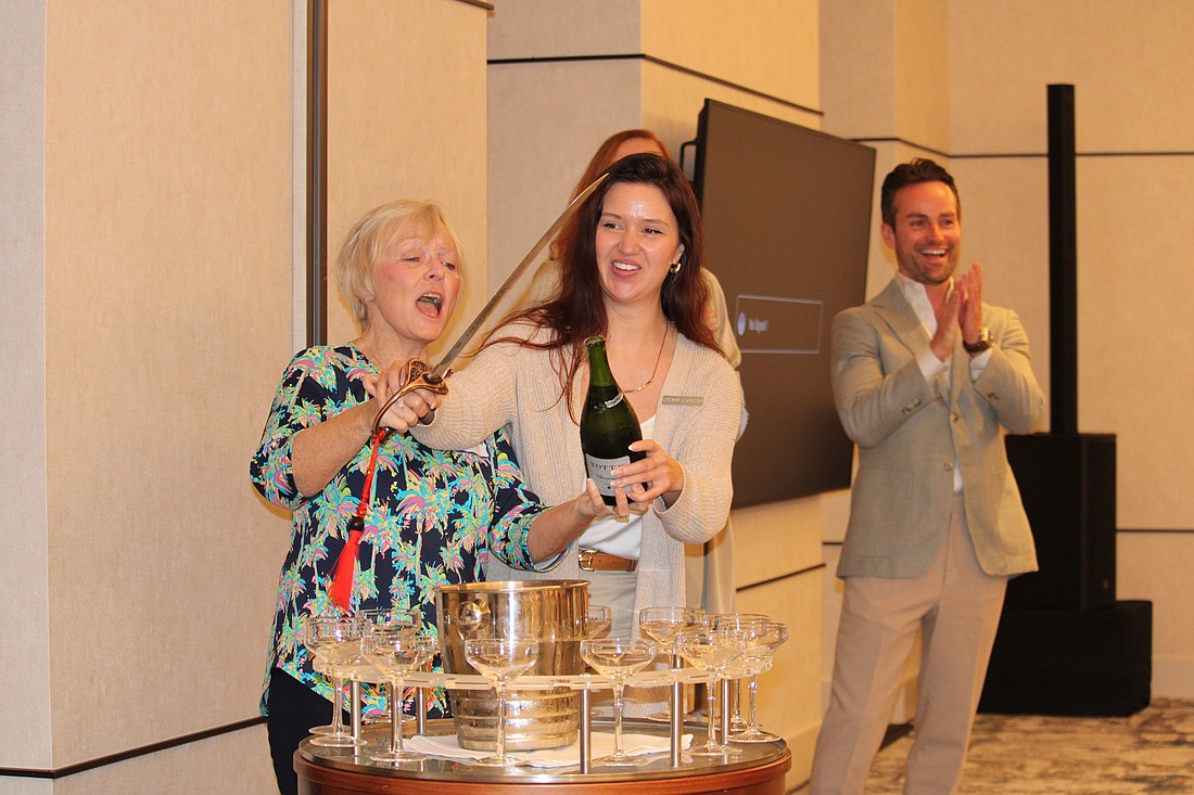 Melody Arndt from Bay Isles successfully at a champagne sabrage during her first-ever Longboat Key Garden Club meeting at The St. Regis Longboat Key Resort.