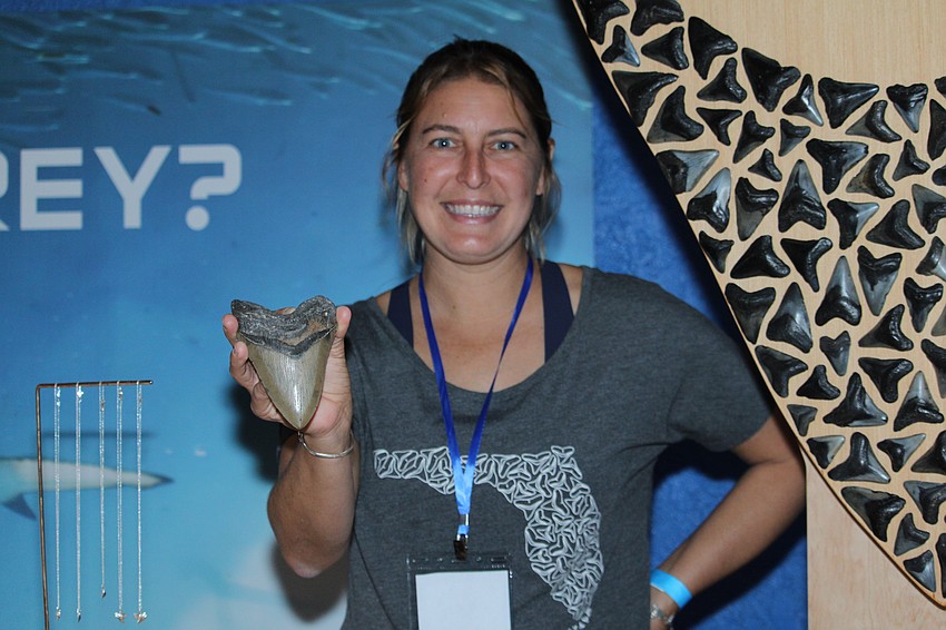 Blair Morrow of Meg Goddess Designs showcases one of her fossilized shark teeth available at her booth.