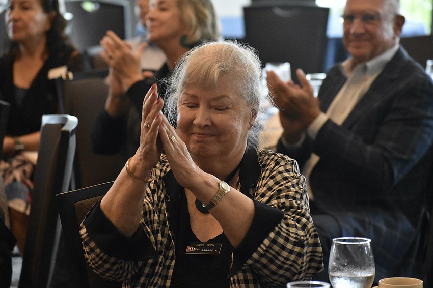 Carol Fisch applauds during the ceremony.