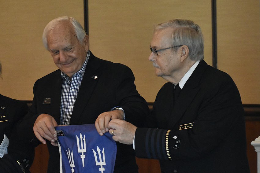 As the flag is passed among past commanders, Leon Warshaw accepts it from Edward Fisch, Jr.