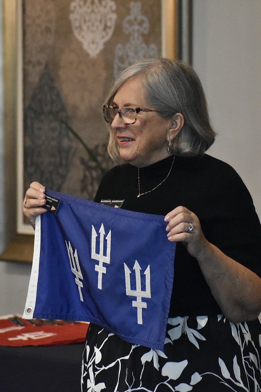 Commander Barbara Warshaw accepts the flag.