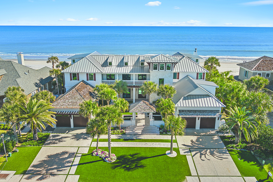 Oceanfront West Indies-style home features five bedrooms, six full and two half-bathrooms, guest suite, media room, wine cellar, courtyard, balconies, patio and porches, two two-car garages, and dune walkover.