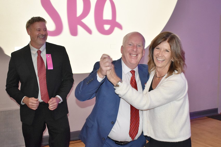 Scott Bush watches as Don Campbell dances with Nancy Lagnese, in celebration of SunCoast Blood Centers receiving a grant.