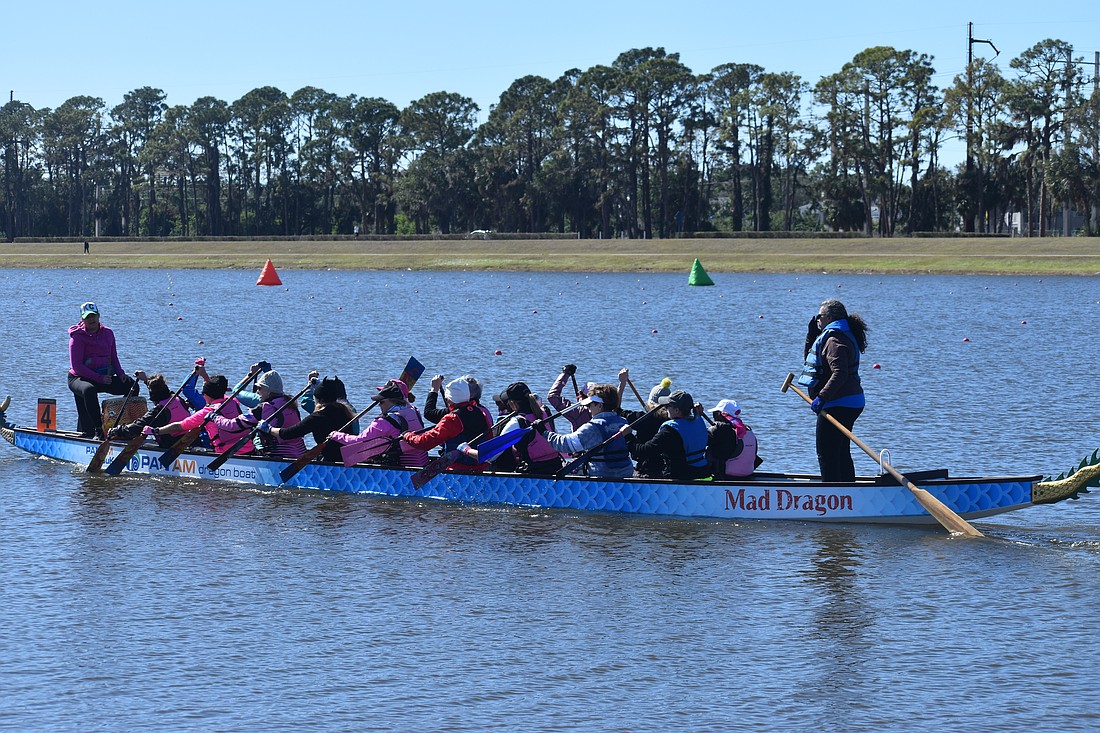 Breast cancer survivor Nadia McConville of Washington state (back), steers the Water Warriors boat. McConville made the switch from paddling to steering after undergoing shoulder and hip replacement surgeries as a result of her cancer.