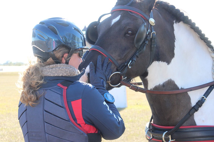 Navigator Carrie Ostrowski-Place gives her horse a kiss at the start line for the marathon portion of the Combined Driving event at TerraNova on Saturday.
