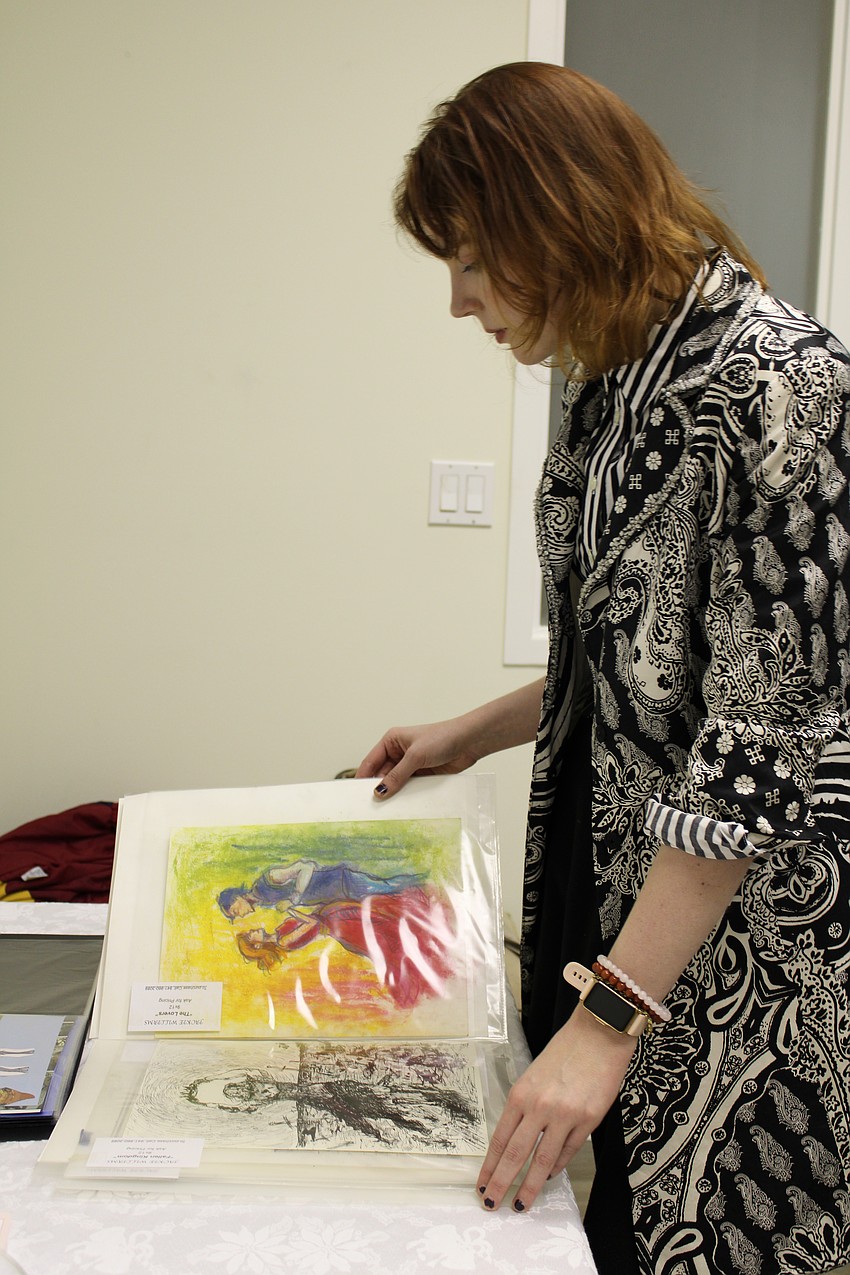 Jackie Williams flips through her art book.