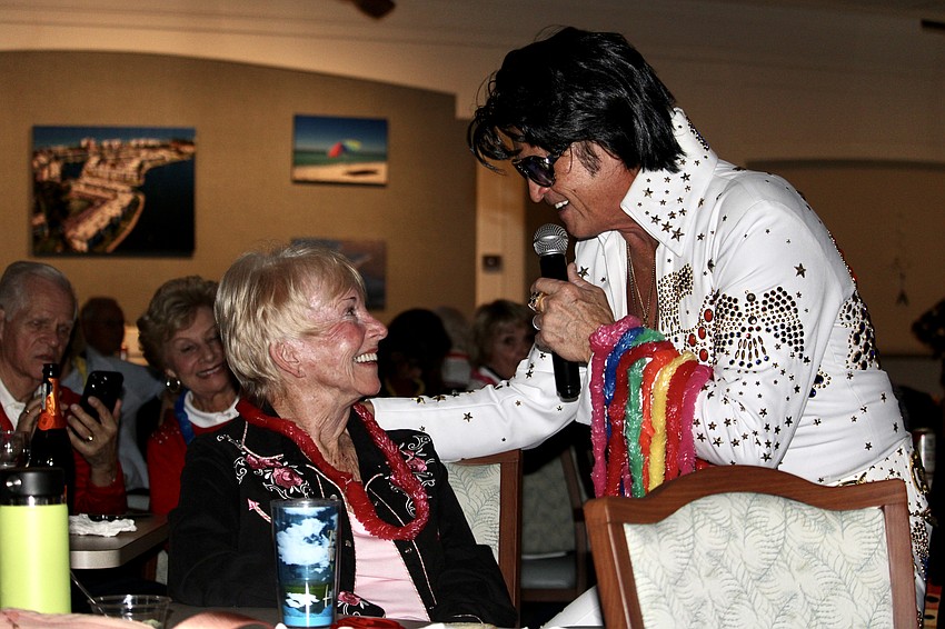 Musician Billy Lindsey, performing as Elvis Presley, gives lei necklaces to all the ladies in the audience, including Sharyn Ford.