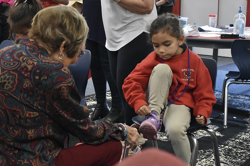 Kindergartener Marley Bowman tries on a pair of new shoes.