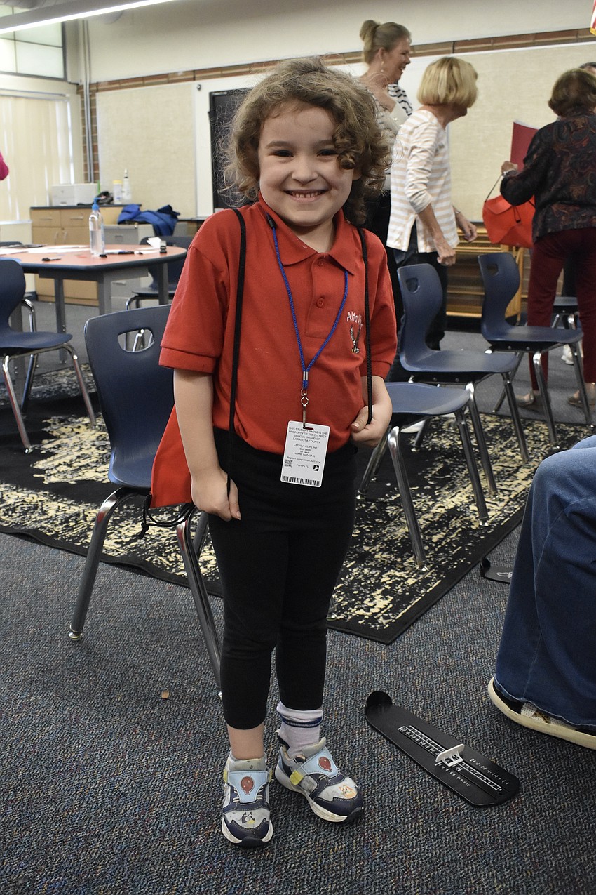 Kindergartener Zoey Smith prepares to head out, with a bag containing her new shoes.