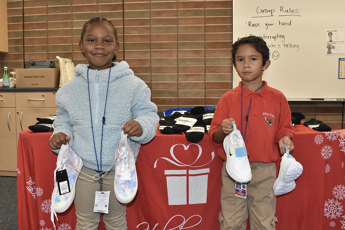 Kindergarteners Milan Brown and Calem Smith pose with their new shoes.