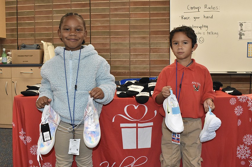 Kindergarteners Milan Brown and Calem Smith pose with their new shoes.