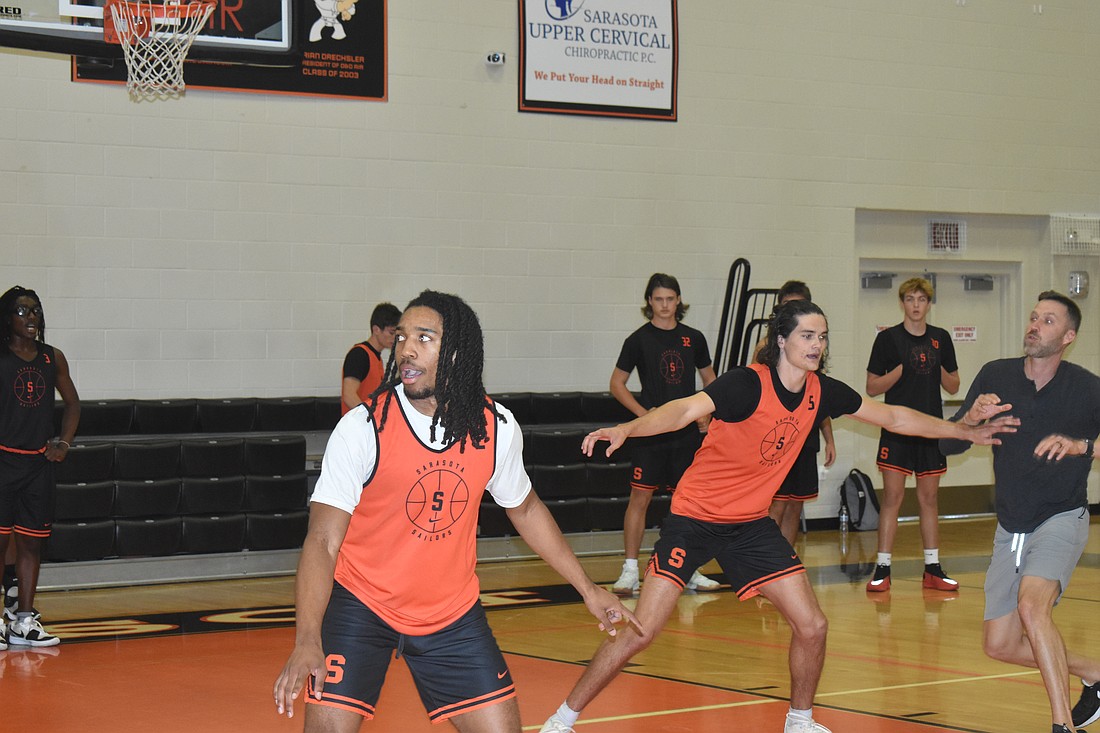 Sarasota High senior Aaron Clark (left) and junior Oliver Boyle work on defensive rotations during practice.