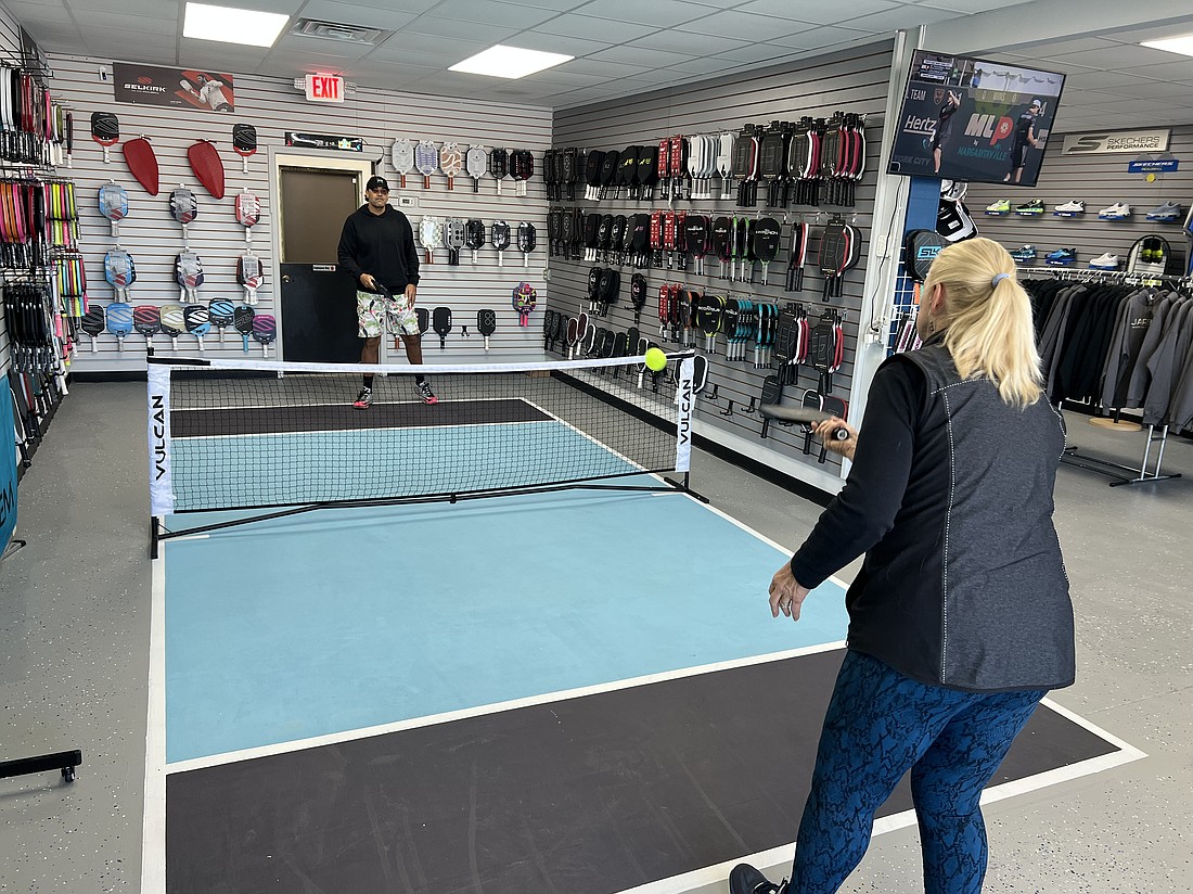 At Jax Pickleball Store in Neptune Beach, co-owner Ty Atkins dinks with a customer on the store’s mini pickleball court.