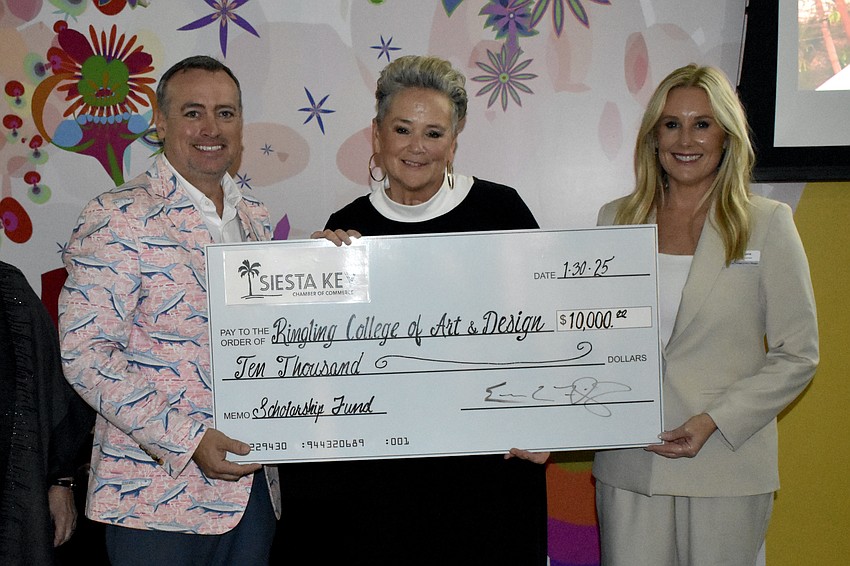 Eric Fleming, board chair of Siesta Key Chamber, presents a check to Lora Wey and Dana Dalpra for funds raised during the Siesta Key Crystal Classic.
