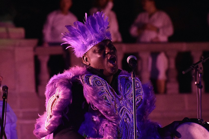 The Flag Boy of Big Chief Romeo Bougere's Mardi Gras Indian tribe, performs with The 79rs Gang. The Flag Boy always carries the banner of the tribe and accompanies the Big Chief.