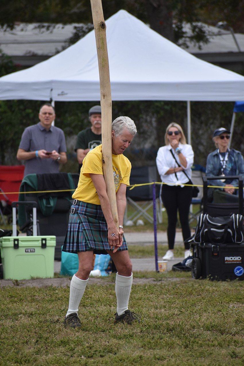 Barb Sinclair does the caber toss.