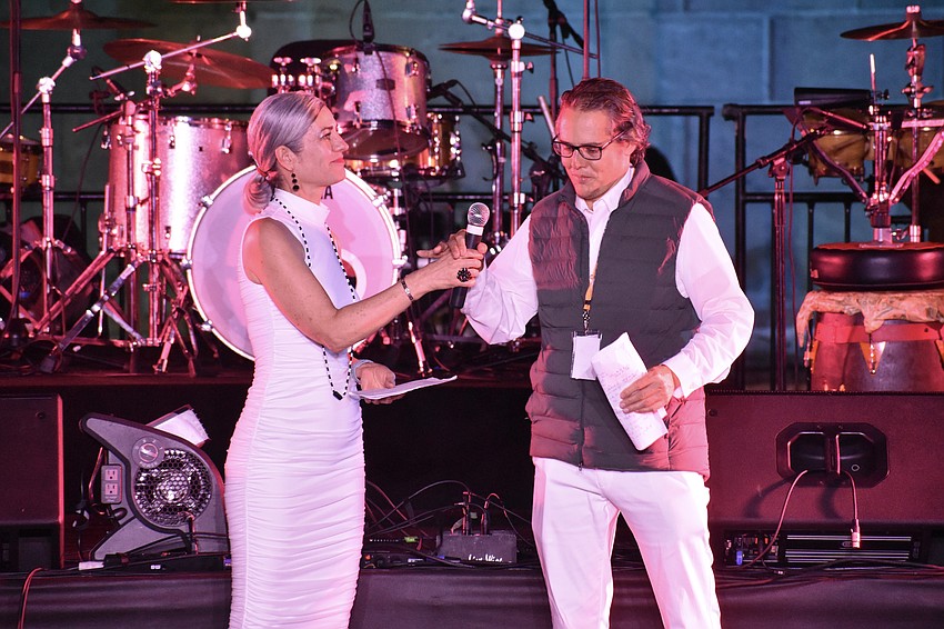 The Ringling's curator of performance Elizabeth Doud hands the microphone to Kelly Kirschner, a board member and co-founder of UnidosNow.