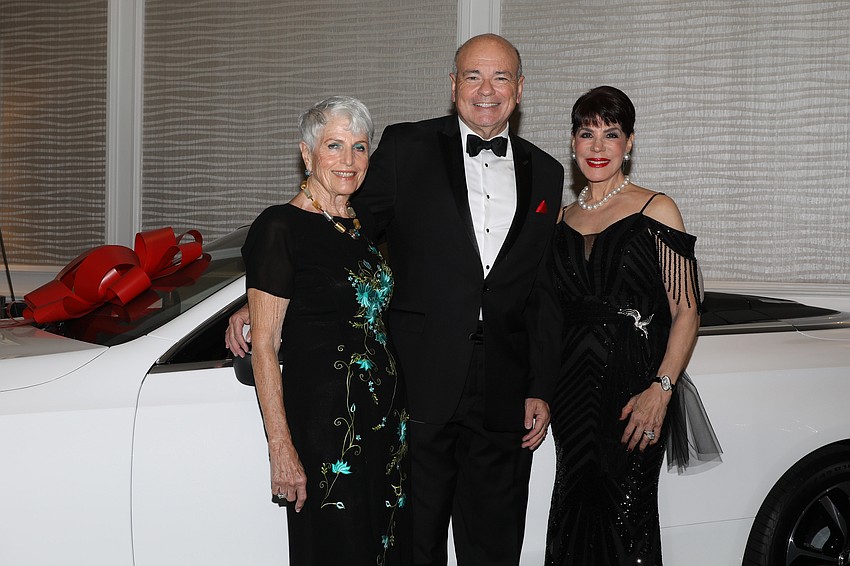 General Director of Sarasota Opera Richard Russell with event co-chairs Edie Chaifetz, Tamara Jacobs and the Mercedes-Benz offered as a raffle prize.