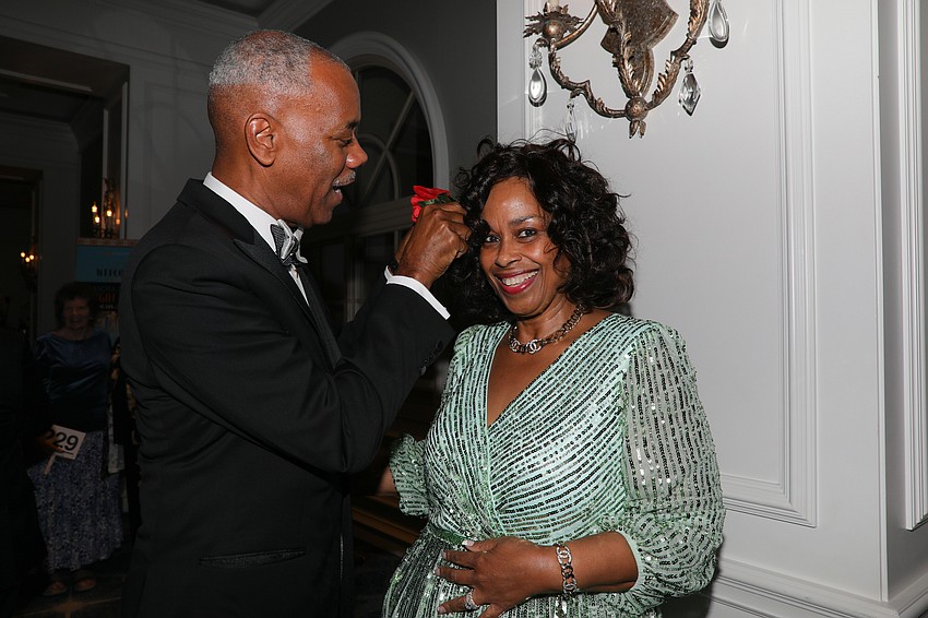 Pamela Mitchel is all smiles as her husband, Kevin, pins a flower in her hair.