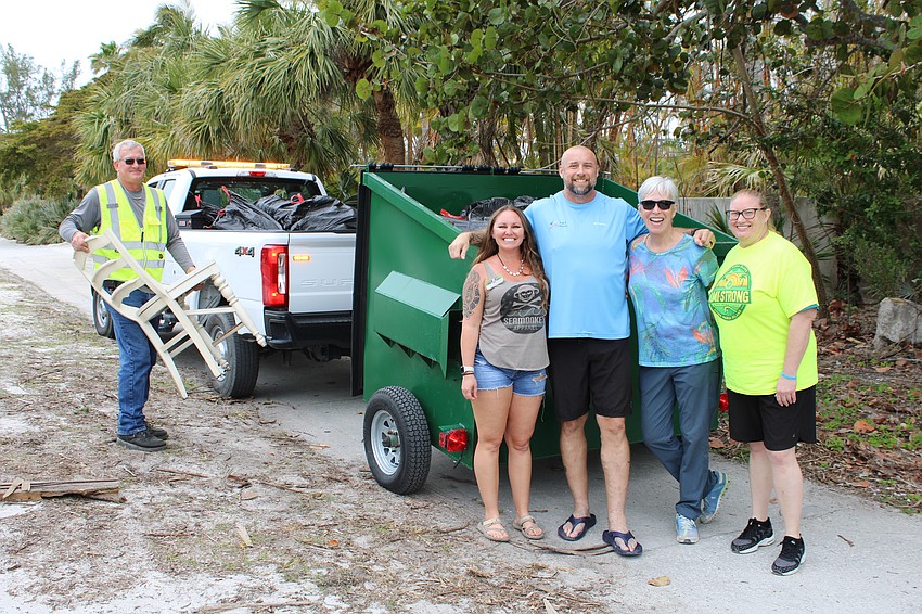 From left, Mike Smith, Alexandra Lowe-Mains, Anthony Moreno, Vilia Johnson and Jennifer Hoffman celebrate a successful cleanup.