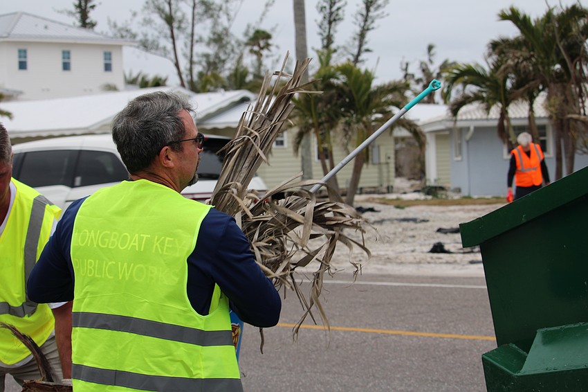 Charlie Mopps, new director of Longboat Key Public Works, loads debris into a dumpster.