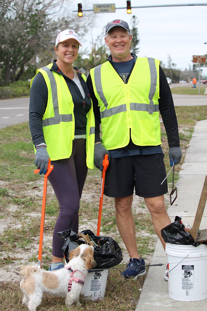 Bryan Williams and Nikol Miller have their trash collection inspected by neighborhood dog Lucy.