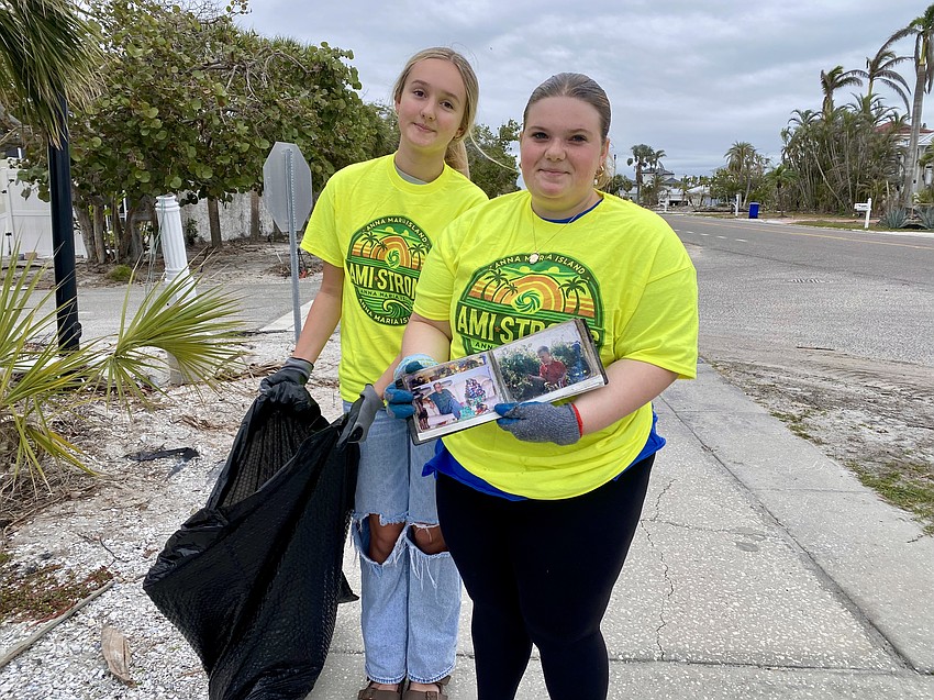 Lina Whyte and Hayden Dolan, two young volunteers in the community cleanup, found a picture album among the roadside debris.