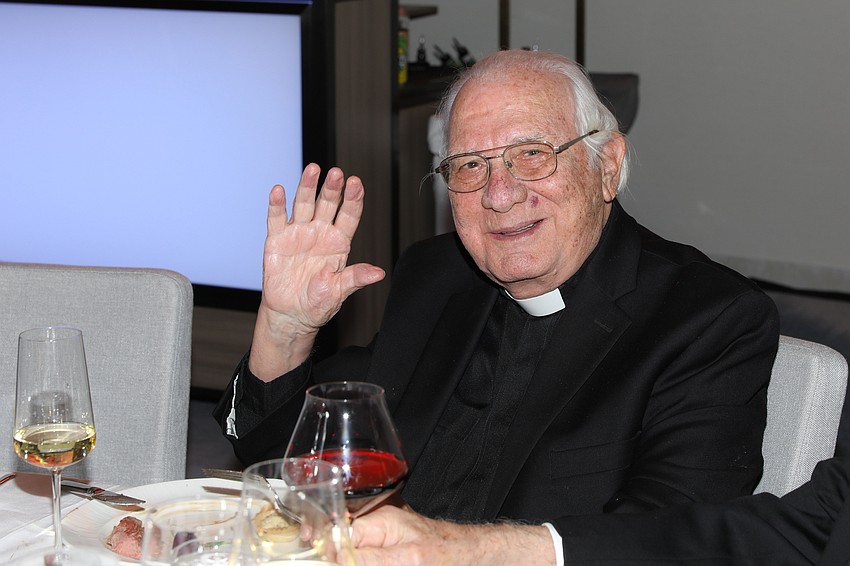 Fr. Fausto Stampiglia gives a recognition wave from his table.