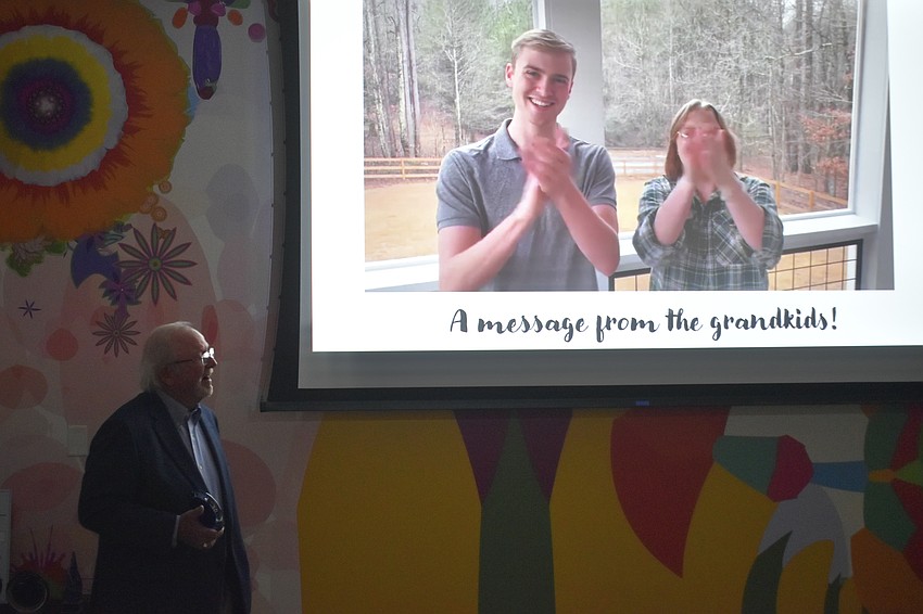 Longtime volunteer Phil Trego is presented with a message from his grandchildren.