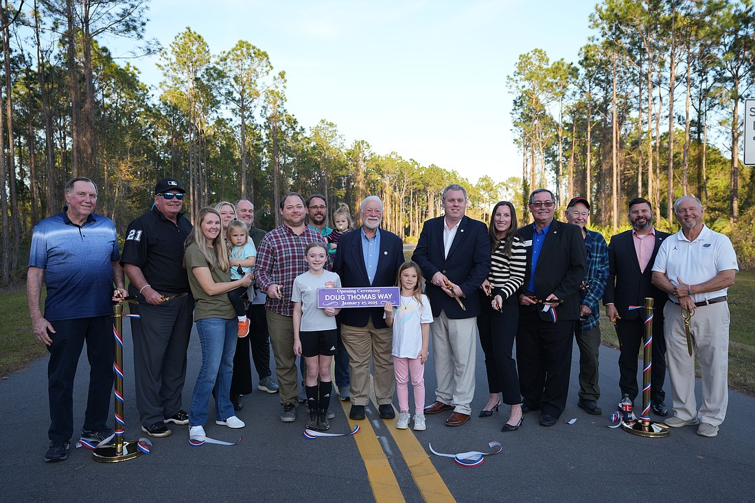 Doug Thomas, center, poses with city officials, friends and family during the ribbon-cutting for the new roadway named in his honor. Photo courtesy of Pauline Dulang/city of Ormond Beach