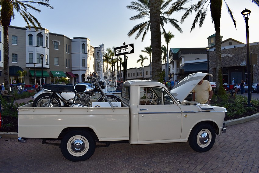 A 1965 Datsun 320 hauls a vintage Honda motorcycle in its cab.